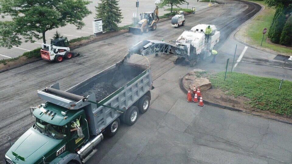Aerial view of a dump truck being loaded with milled asphalt